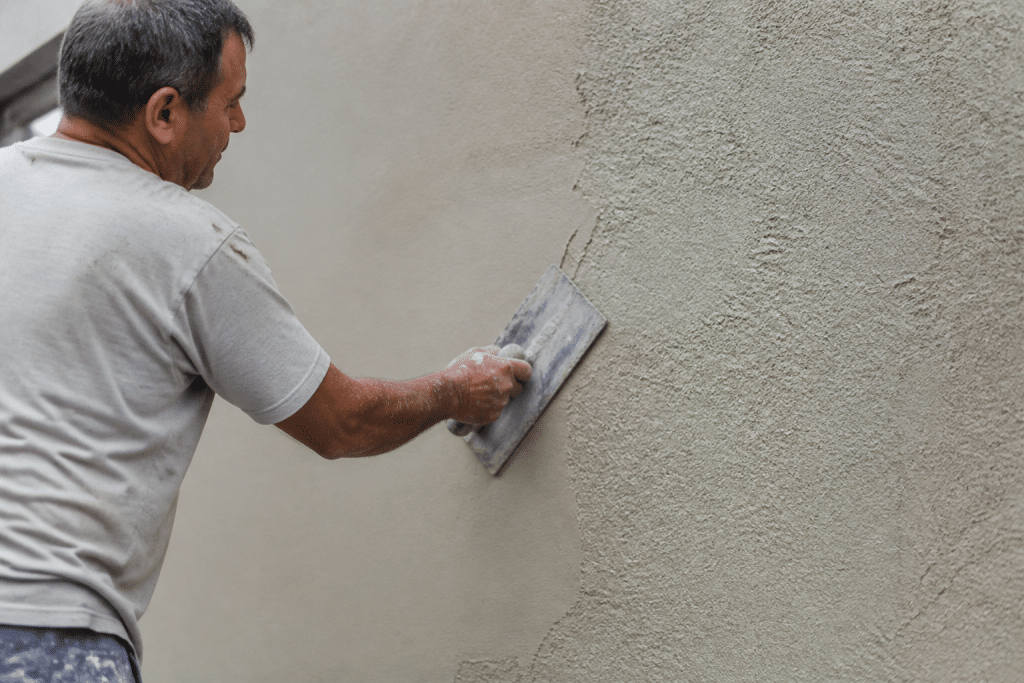 Mur enduit avec taloche créant texture lisse et grain rustique