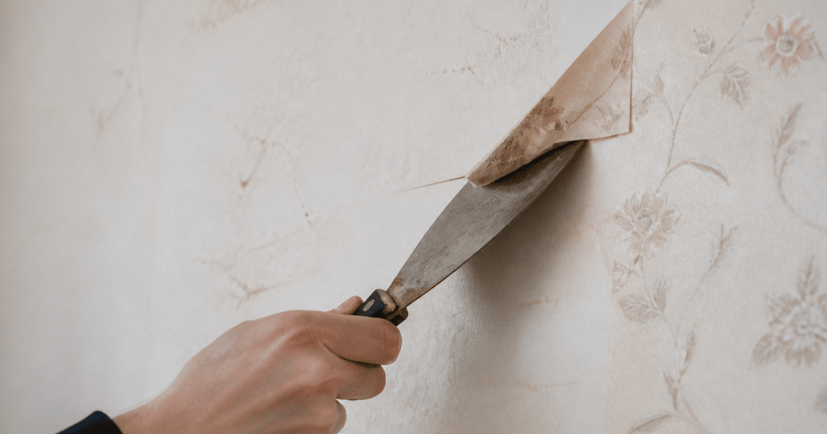 Spatule levant délicatement le coin d'un papier peint