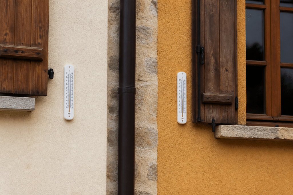 Deux maisons avec thermometres affichant temperatures differentes