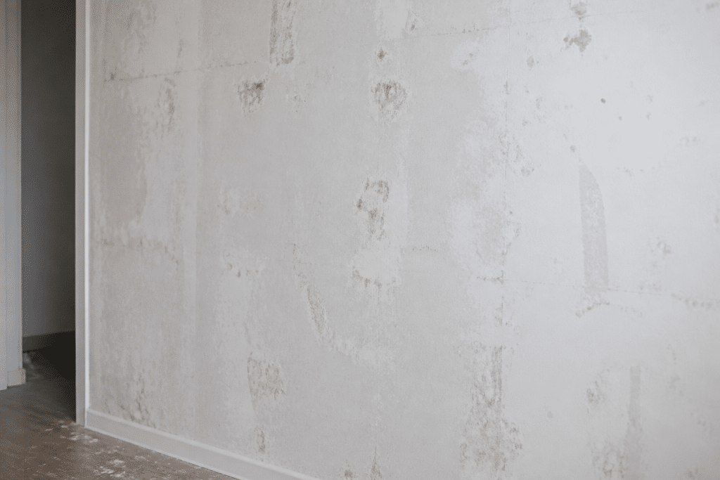 Mur blanc nu avec traces poussiereuses apres retrait papier peint