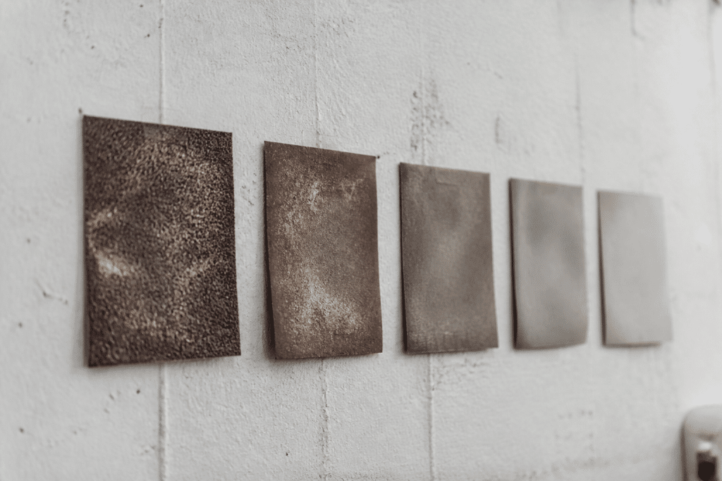 Succession papiers abrasifs grains croissants sur surface murale