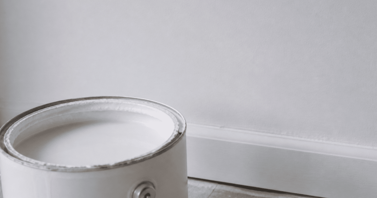 Pot peinture ouvert montrant surface mate profonde sur mur blanc