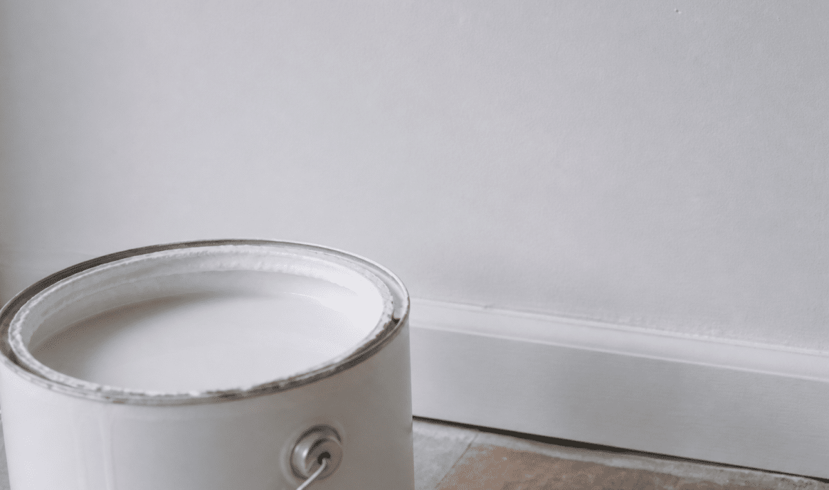 Pot peinture ouvert montrant surface mate profonde sur mur blanc