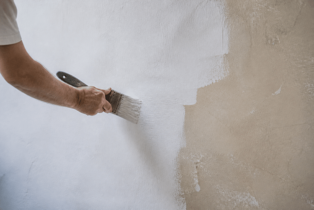 Mur ancien repeint avec pinceau montrant nouvelle couche opaque