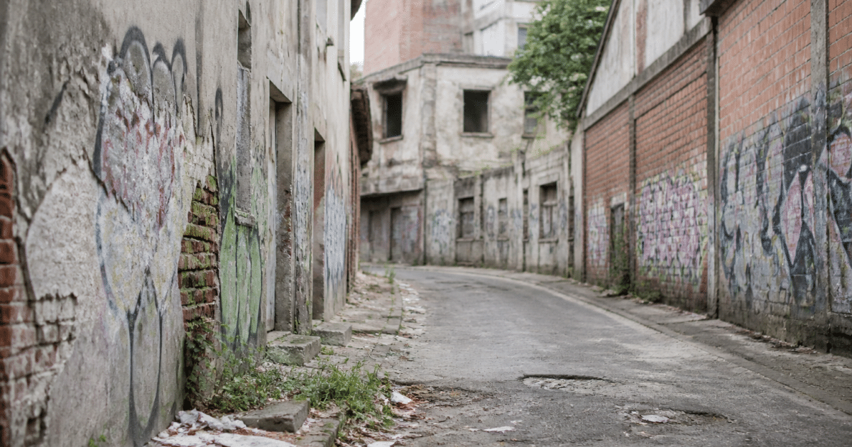 Rues délabrées avec bâtiments détériorés et graffitis visibles partout