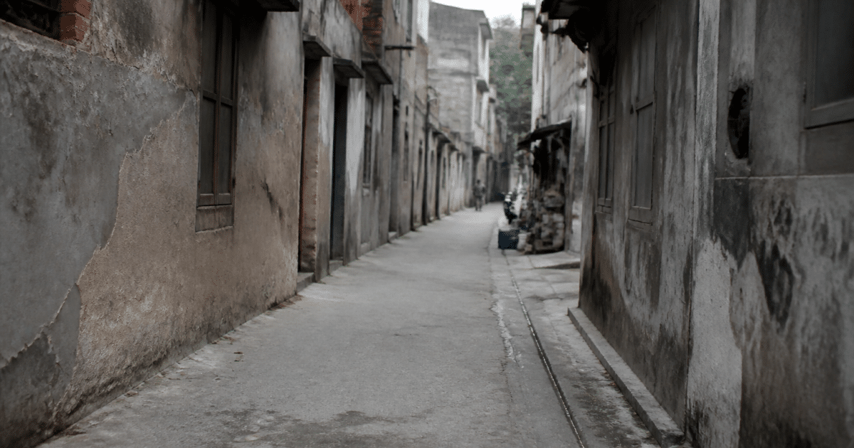 Rue urbaine avec immeubles deteriores et facades grises usees