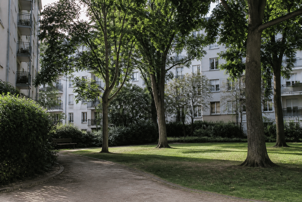 Parc urbain verdoyant entouré d'immeubles résidentiels calmes