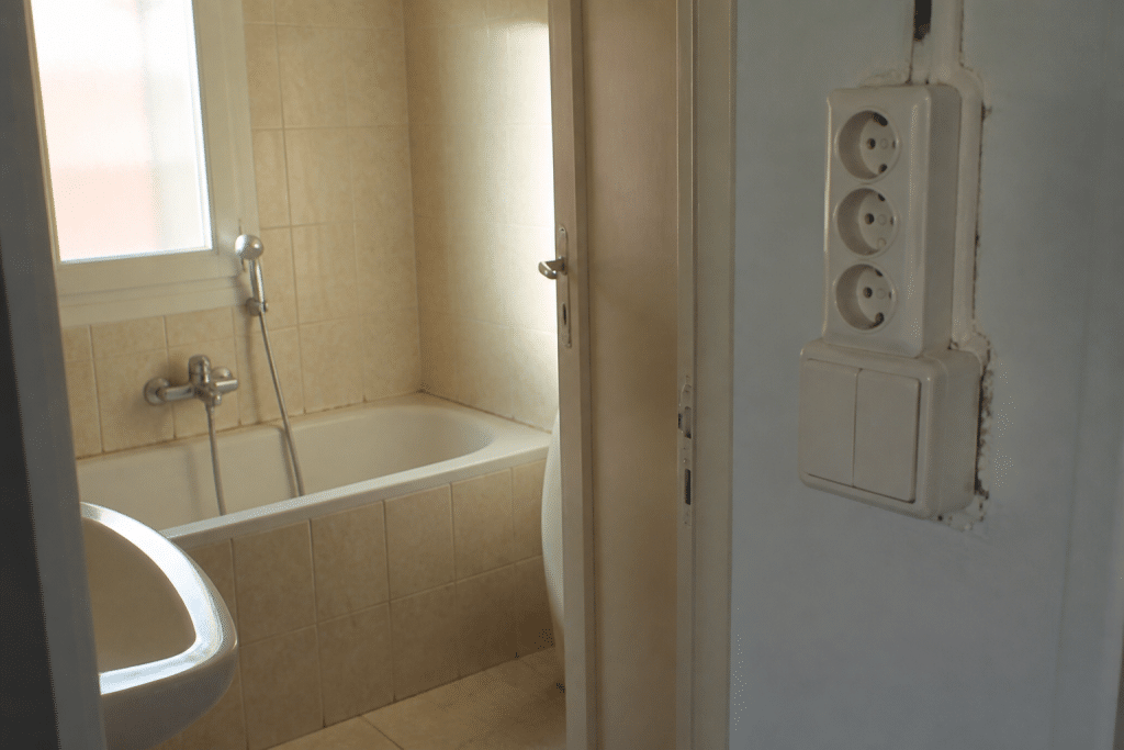 Salle de bain avec baignoire et panneaux d'interdiction électrique