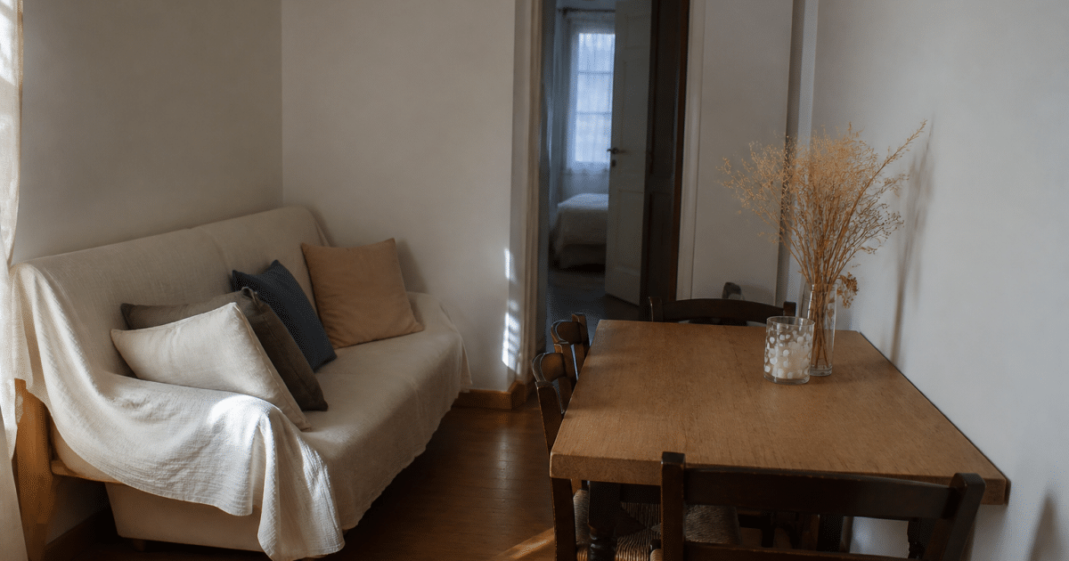 Petit salon-salle a manger avec canape et table contre murs