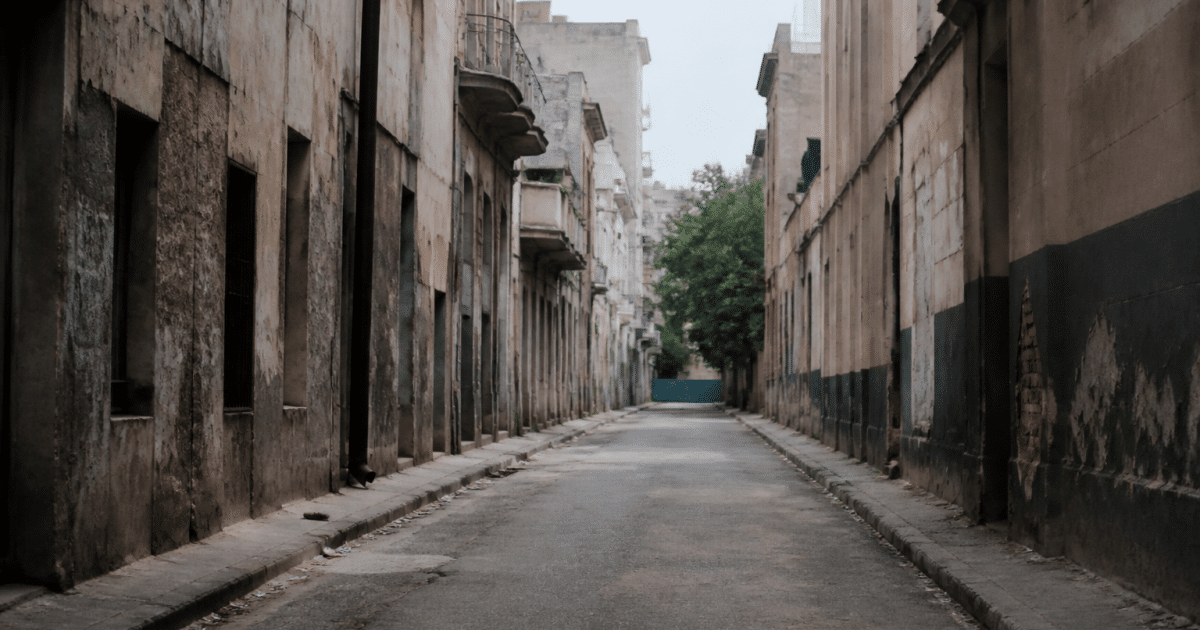 Rue urbaine déserte avec immeubles dégradés et murs tagués