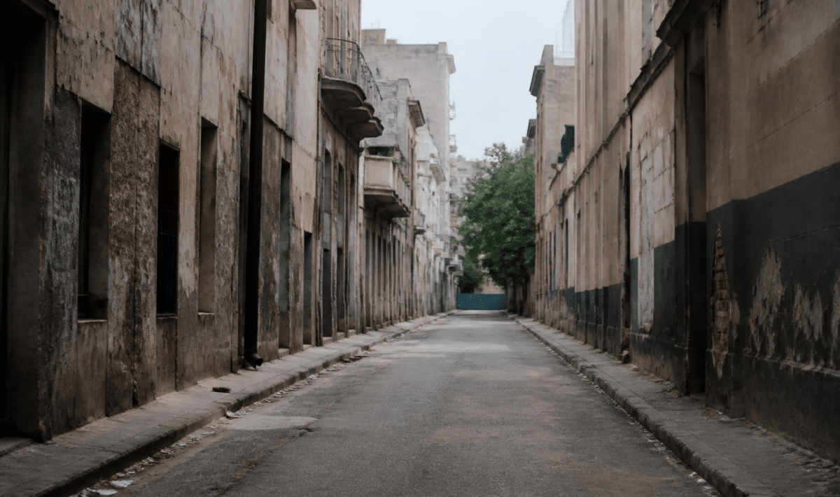 Rue urbaine déserte avec immeubles dégradés et murs tagués