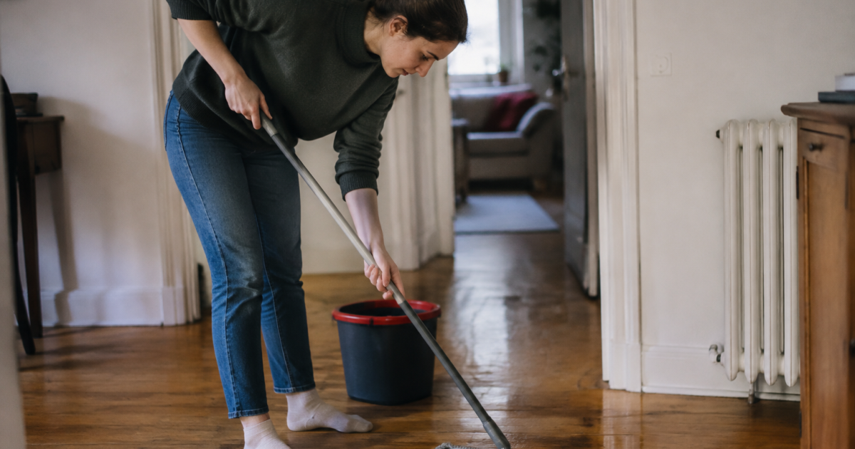 Personne penchee passe serpillere sur le parquet bois