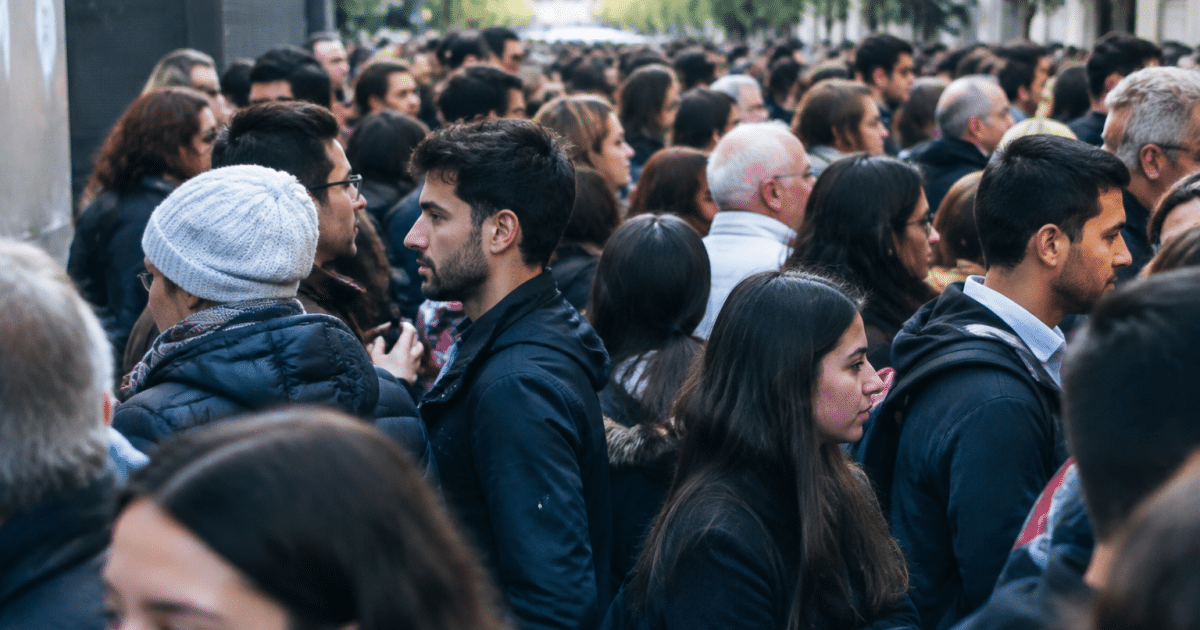 Foule dense de personnes debout cote a cote dans rue urbaine
