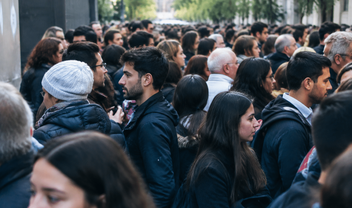 Foule dense de personnes debout cote a cote dans rue urbaine