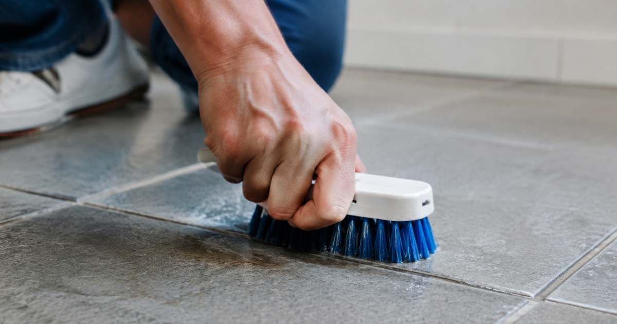 Brosse frotte horizontalement zones grises entre carreaux